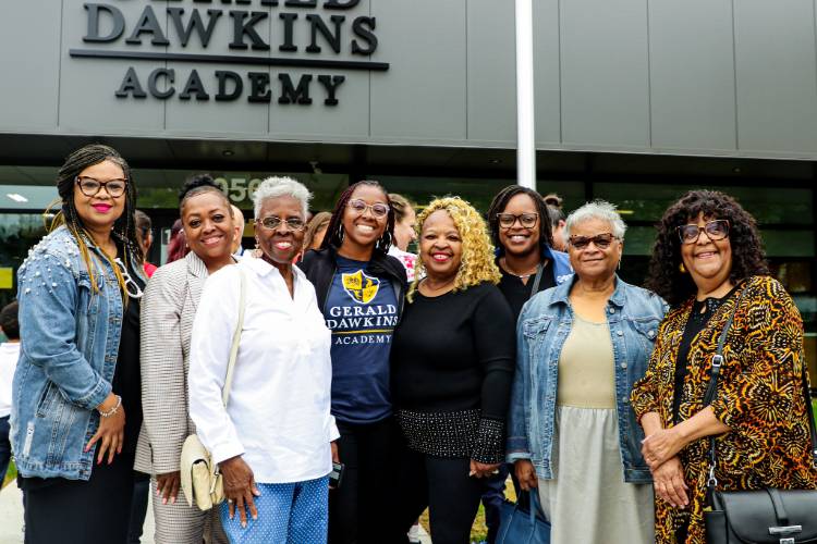 A multi-generational group of women standing in front of a new elementary school